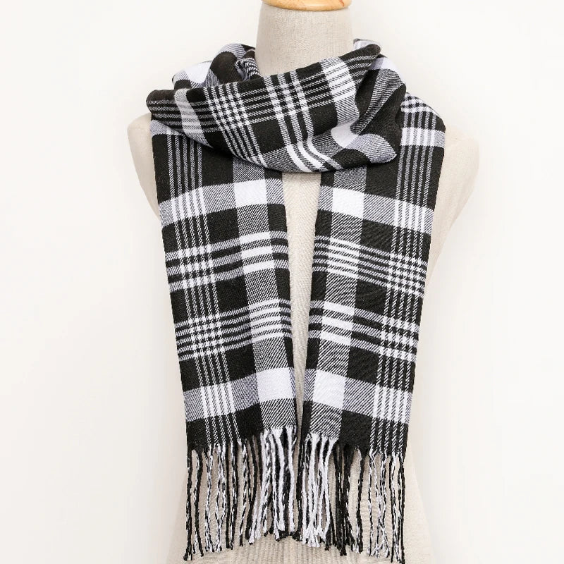 Black and white plaid scarf with fringes on a mannequin against a white background