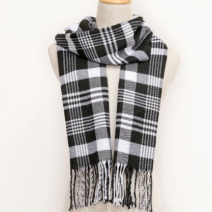 Black and white plaid scarf with fringes on a mannequin against a white background