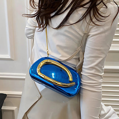 Person wearing a white outfit with a blue and gold handbag.