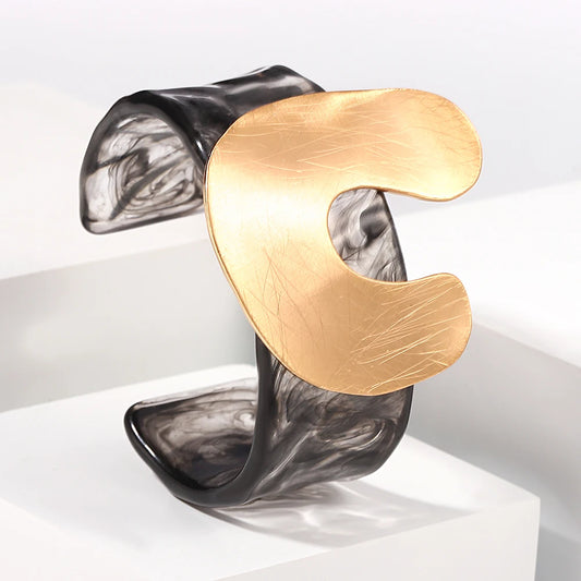 Gold and black abstract bangle on a white background