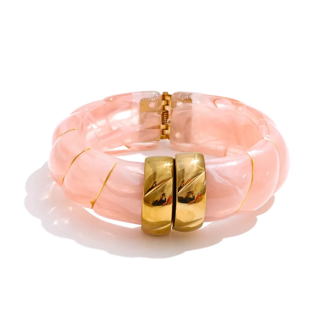 Pink bracelet with gold accents on a white background