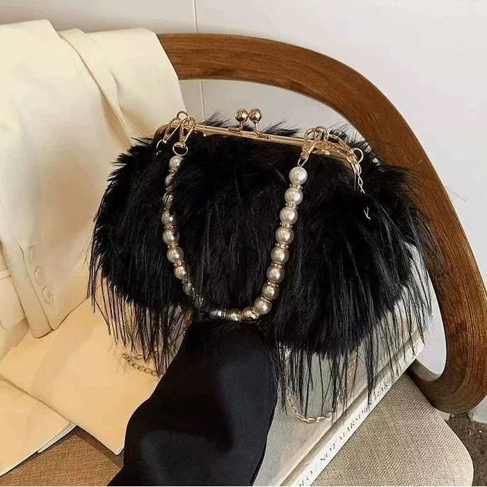 Black feathered handbag with pearl accents on a chair