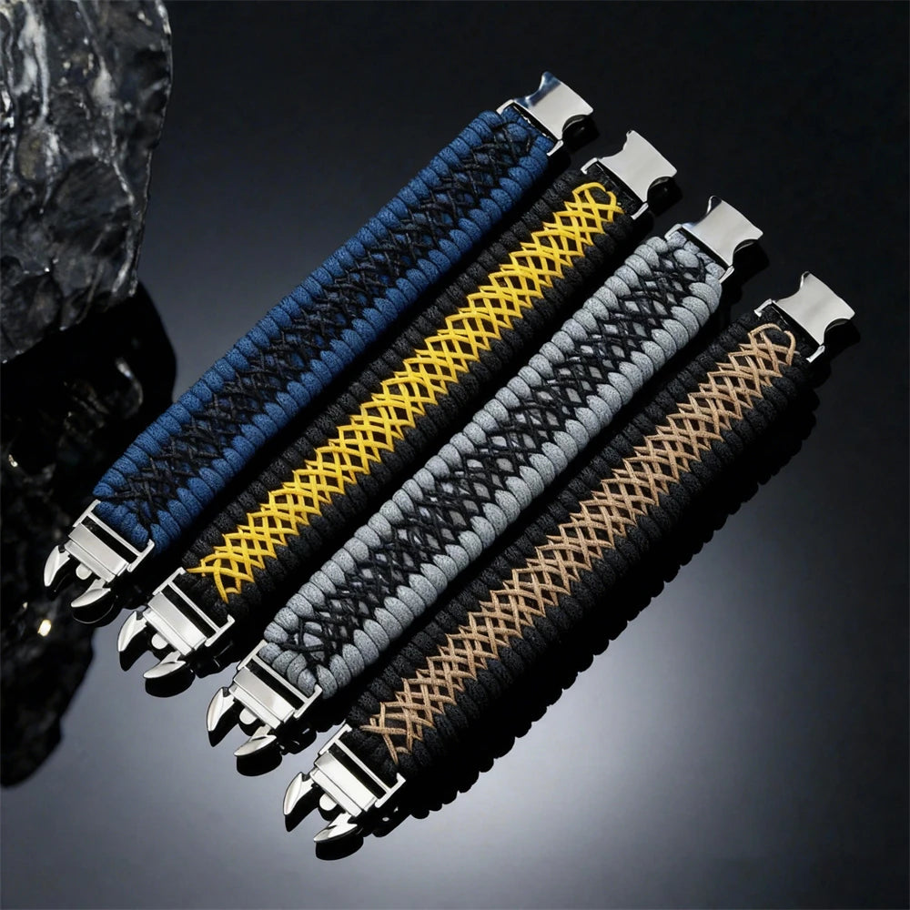 Four braided woven paracord bracelets with silver metal clasp ends, arranged diagonally on a dark reflective surface. The bracelets are shown in blue, yellow-and-black, grey-and-black, and tan-and-black colour combinations.