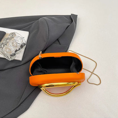 Orange clutch bag with gold accents on a light grey background