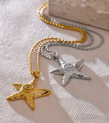 Two star-shaped pendants on gold and silver chains against a textured surface.