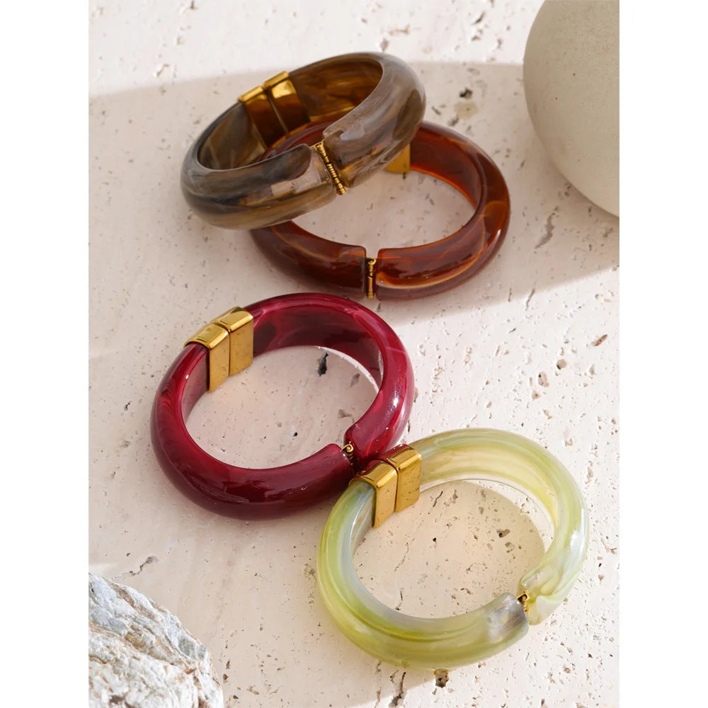 Three colourful bangles on a textured surface