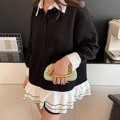 Person wearing a black and white outfit with a green clutch in an indoor setting