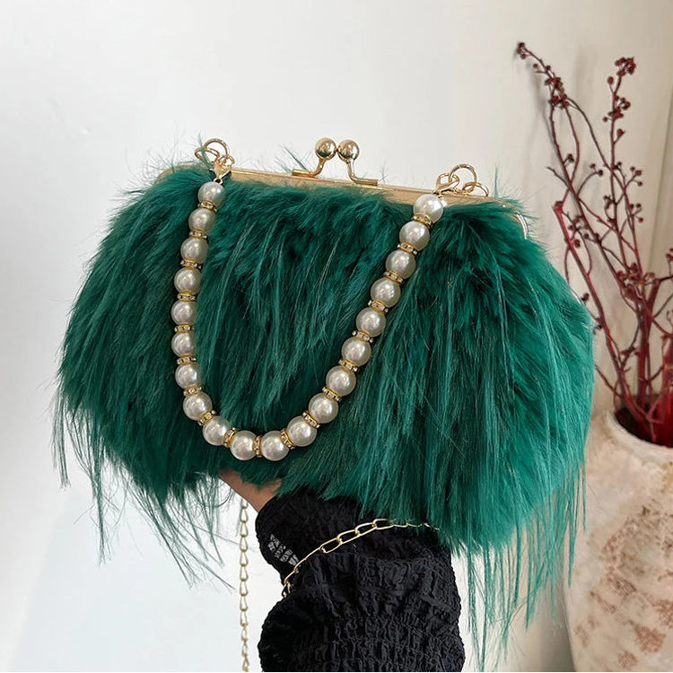 Green feathered handbag with pearl chain on a neutral background
