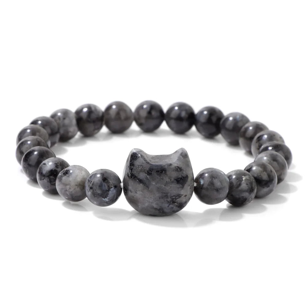 Grey beaded bracelet with a cat-shaped charm on a white background