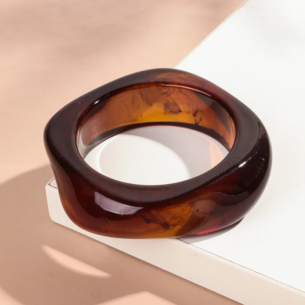 Brown resin bangle on a light beige surface