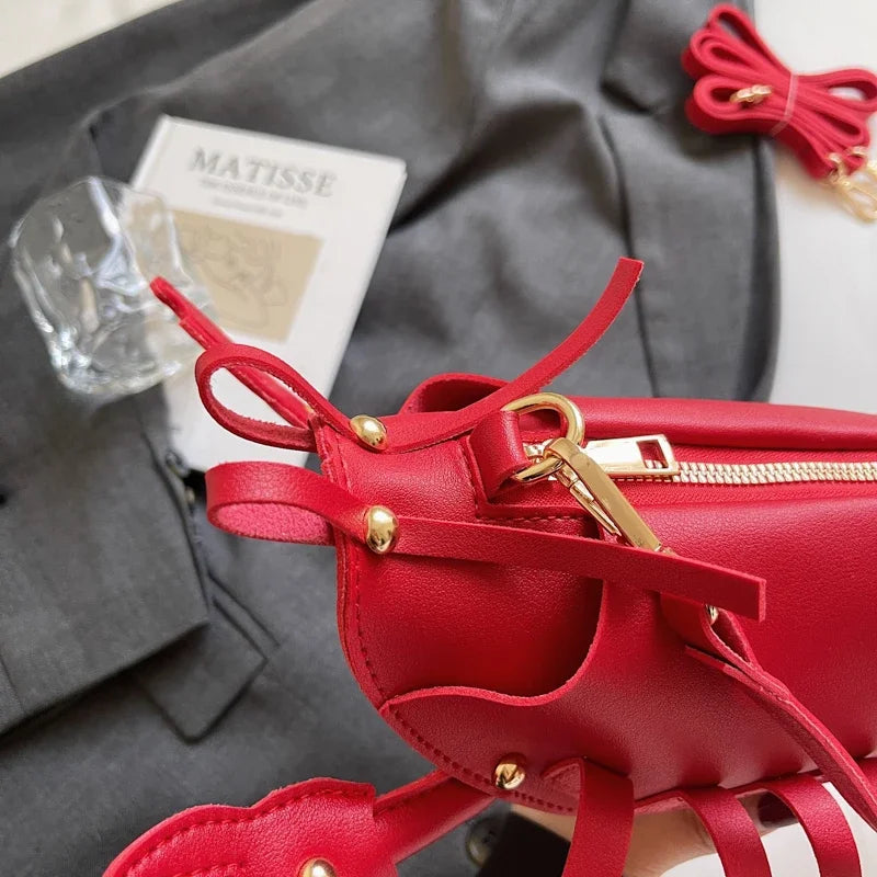 Red handbag with gold accents on a grey surface