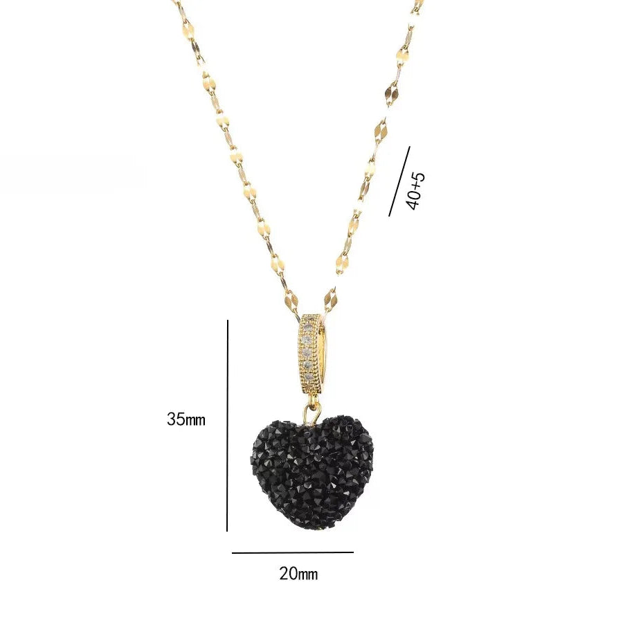 Gold necklace with a black heart-shaped pendant on a white background