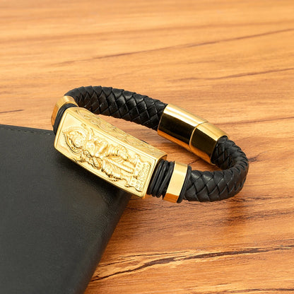 Black braided leather bracelet with gold accents on a wooden surface