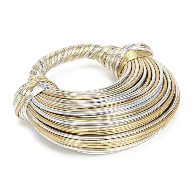 Handbag made of interwoven gold and silver leather on a white background