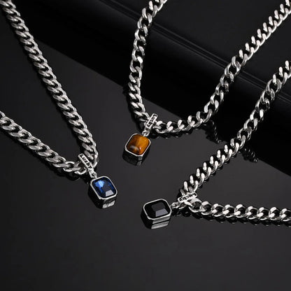 Three silver chain necklaces with gemstone pendants on a black background