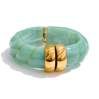 Green marbled bracelet with gold accents on a white background
