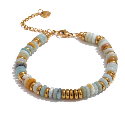 Bracelet with gold and white beads on a white background.