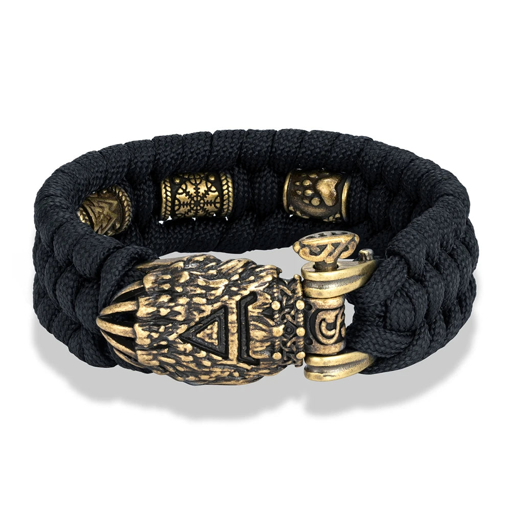 Black braided bracelet with gold metal clasp and decorative beads on a white background