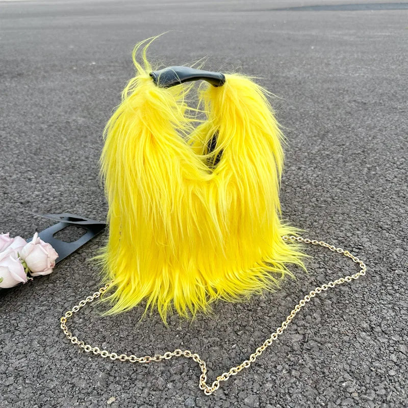 Yellow furry handbag with a chain strap on a grey surface
