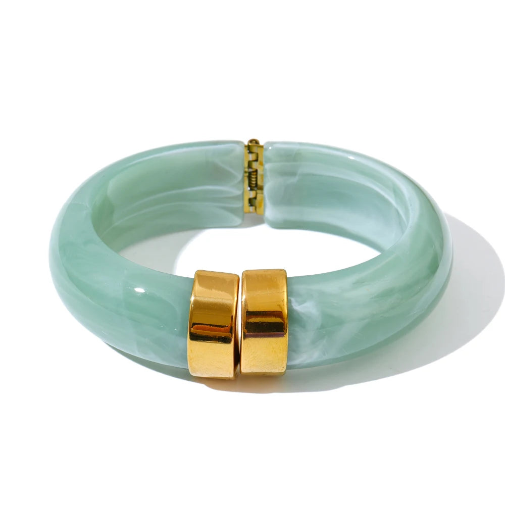 Green bracelet with gold clasp on a white background
