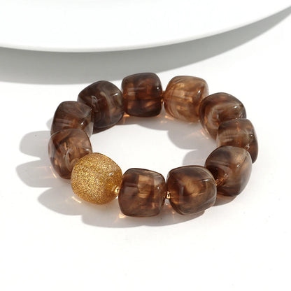 Brown beaded bracelet with a gold accent on a white background
