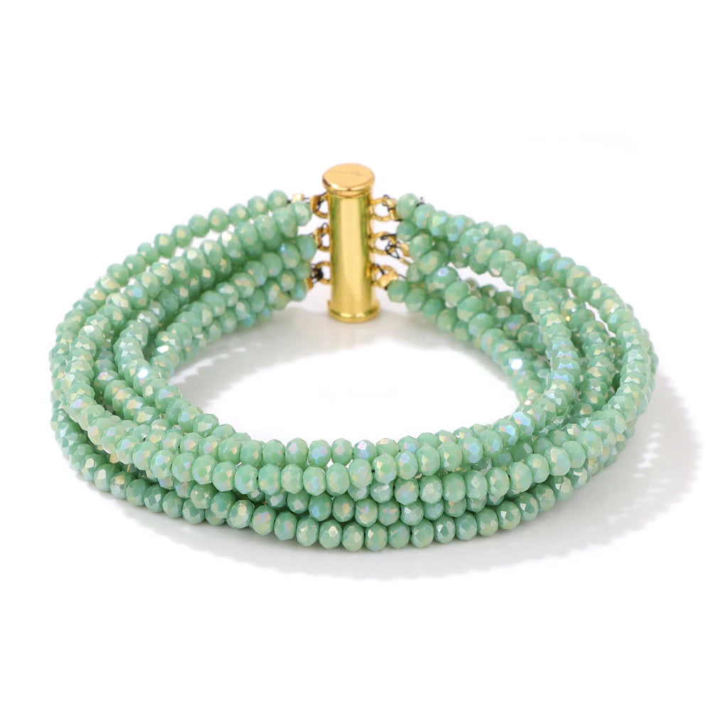 Green beaded bracelet with a gold clasp on a white background