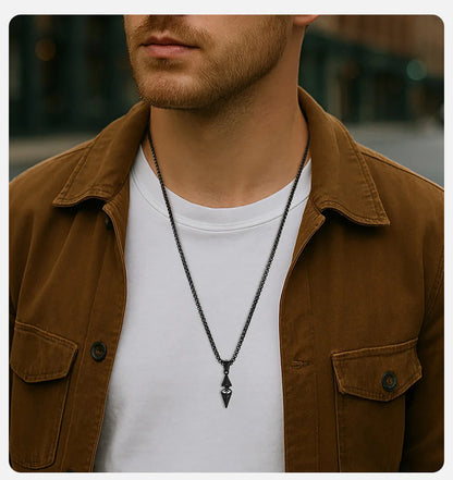 Man wearing a brown jacket and white shirt with a black necklace.