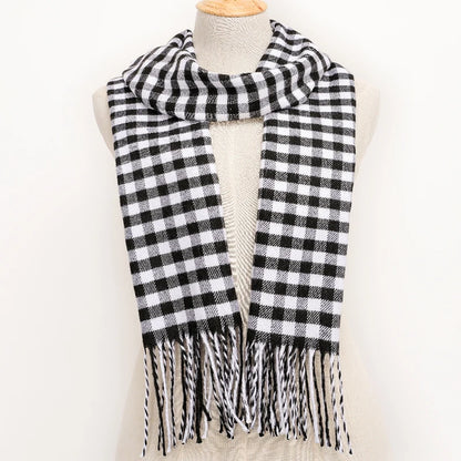 Black and white checkered scarf with fringes on a mannequin against a white background