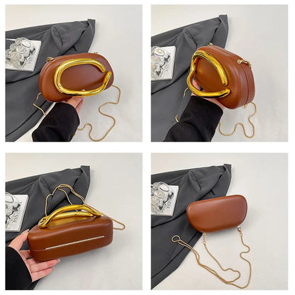 Brown handbag with gold handle held by a person on a white background