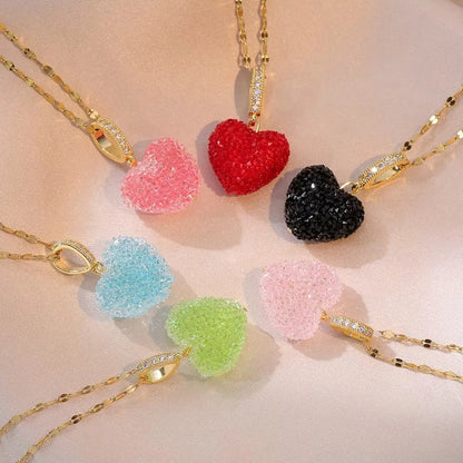 Colourful heart-shaped pendants on gold chains against a light pink background
