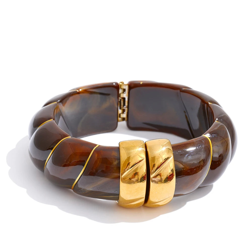 Brown bracelet with gold accents on a white background