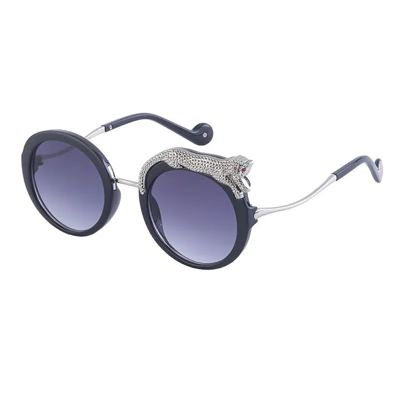 Sunglasses with a decorative animal figure on the arm against a white background