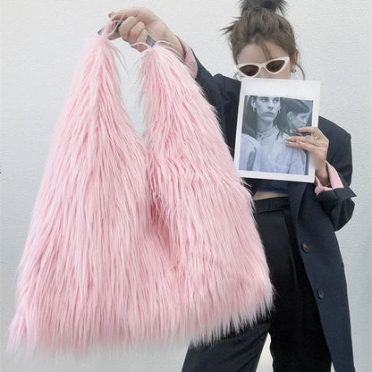 Person holding a pink feathered bag and a photo album with a white background