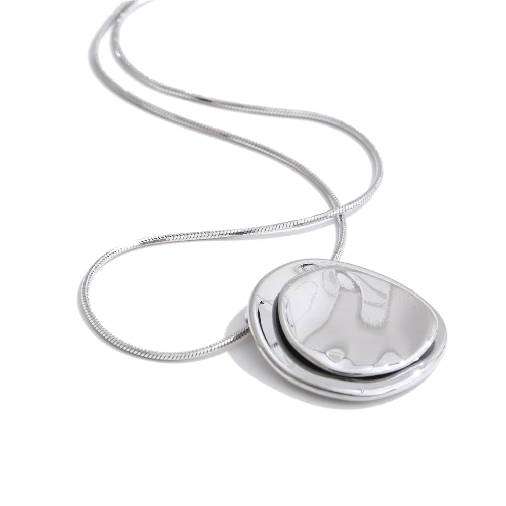 Silver necklace with a round pendant on a white background