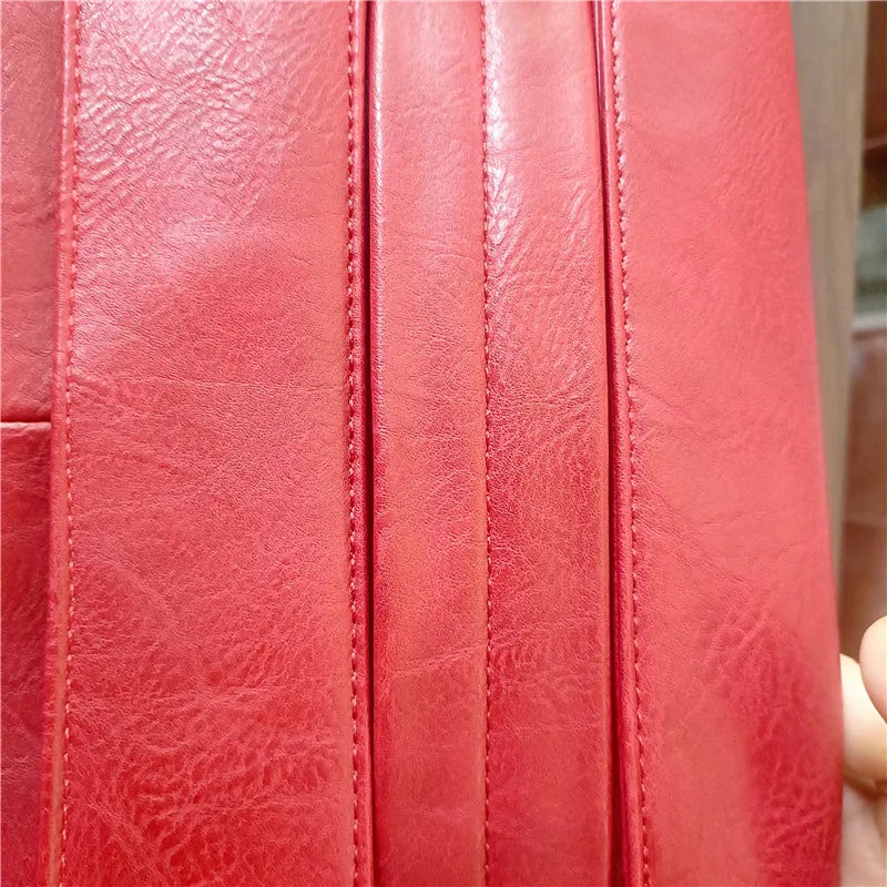Close-up of a red leather surface with visible stitching
