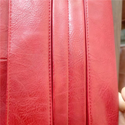 Close-up of a red leather surface with visible stitching