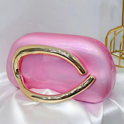 Light pink clutch with gold handle on a white surface