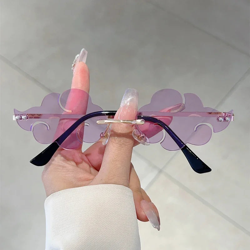 Sunglasses with purple and black design held by a hand against a neutral background