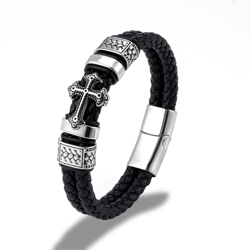 Black braided leather bracelet with silver-tone metal accents, including a cross charm, textured spacer beads, and a magnetic clasp, shown on a white background.