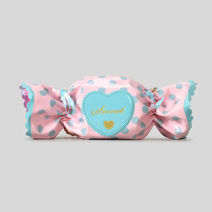 Pink candy shaped bag with polka dots and a heart-shaped label on a grey background