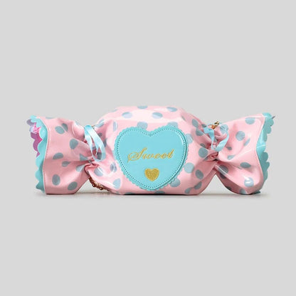 Pink candy shaped bag with polka dots and a heart-shaped label on a grey background