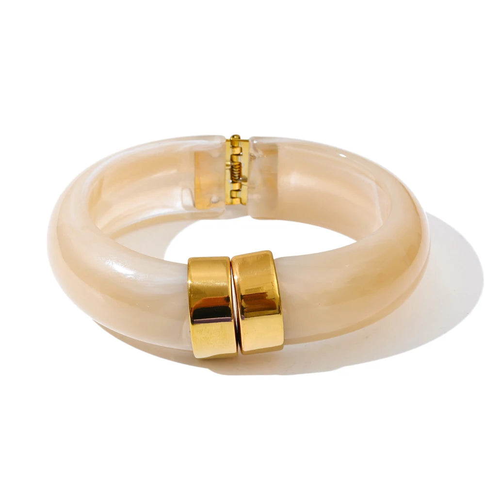 Beige bracelet with gold clasp on a white background
