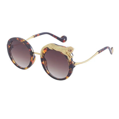 Sunglasses with tortoiseshell frame and gold accents on a white background.