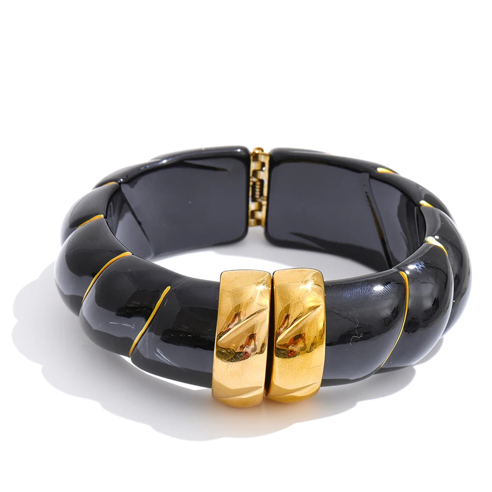Black bracelet with gold accents on a white background