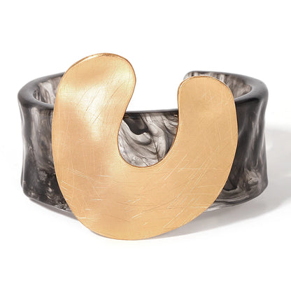Gold and black bracelet on a white background