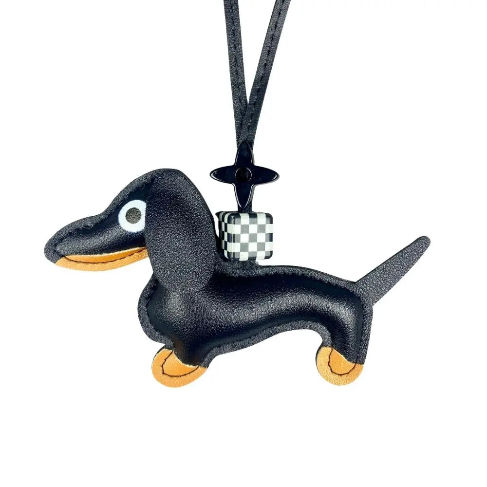 Black dachshund-shaped bag charm on a white background