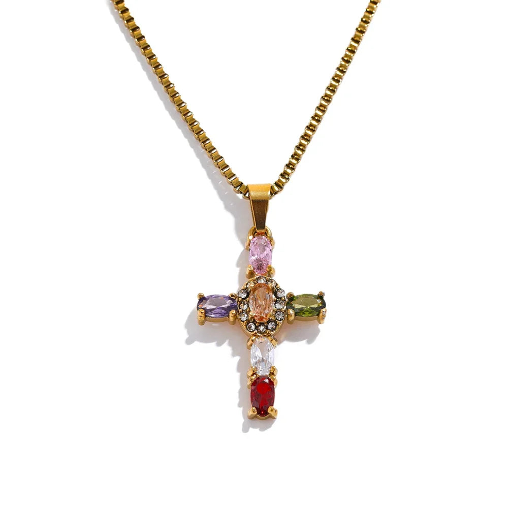 Gold cross pendant with colourful gemstones on a white background
