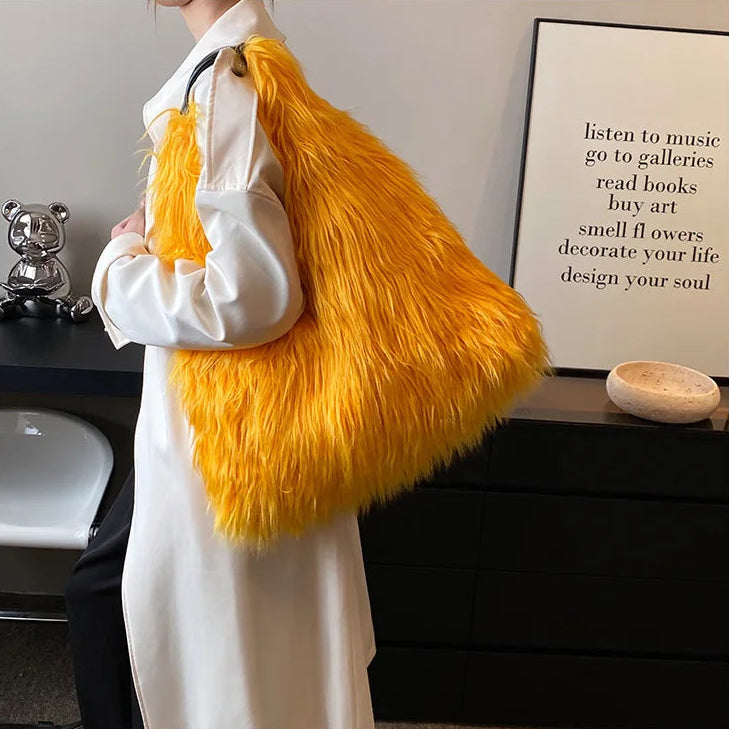 Person holding an orange fluffy bag in a room with decor elements.