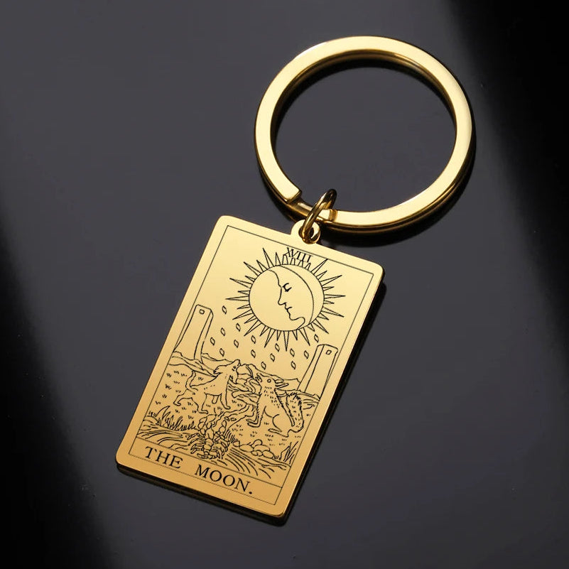 Gold keychain with 'The Moon' tarot card design on a dark background