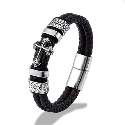 Black braided leather bracelet with silver-tone metal accents, including a cross charm, textured spacer beads, and a magnetic clasp, shown on a white background.